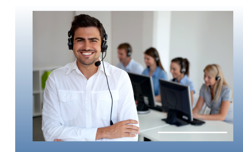 customer service rep smiling with workers behind him 